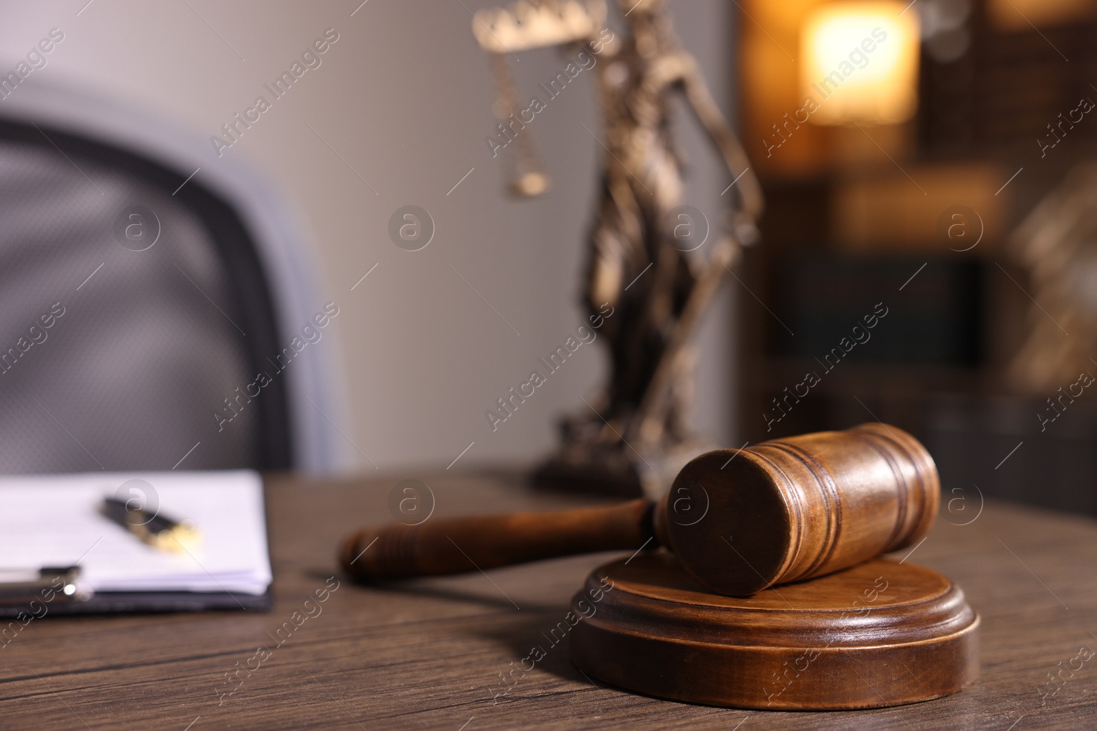 Photo of Judge's gavel on wooden table in office, closeup