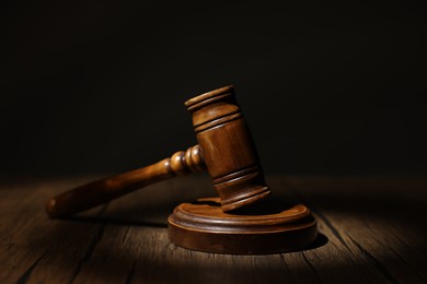 Photo of Judge's gavel on wooden table in office, closeup