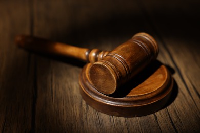 Photo of Judge's gavel on wooden table in office, closeup