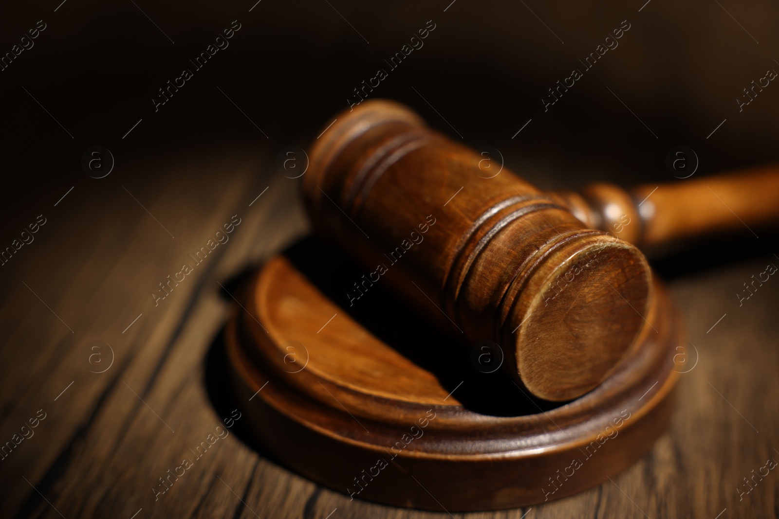 Photo of Judge's gavel on wooden table in office, closeup