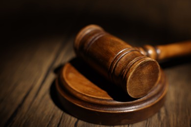 Photo of Judge's gavel on wooden table in office, closeup