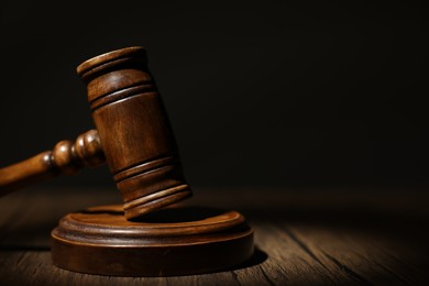 Photo of Judge's gavel on wooden table in office, closeup. Space for text