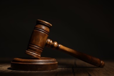 Photo of Judge's gavel on wooden table in office, closeup