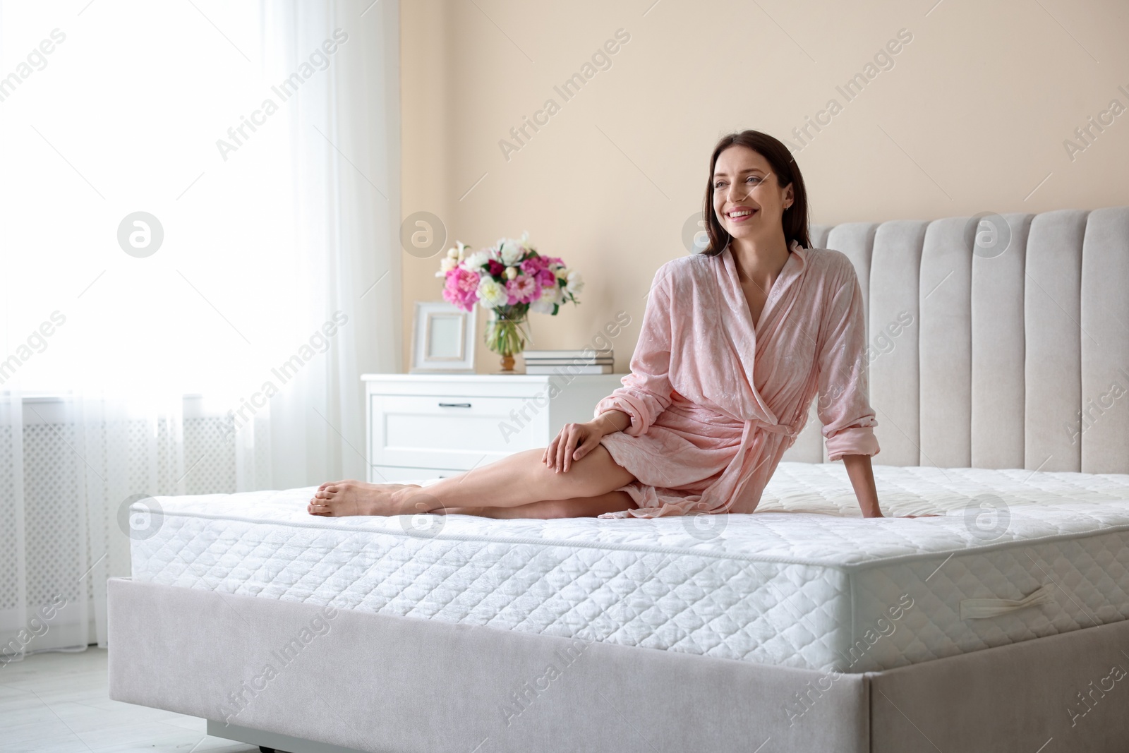 Woman on bed with orthopedic mattress at home Photo of Woman on bed with orthopedic mattress at home