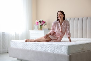 Photo of Woman on bed with orthopedic mattress at home