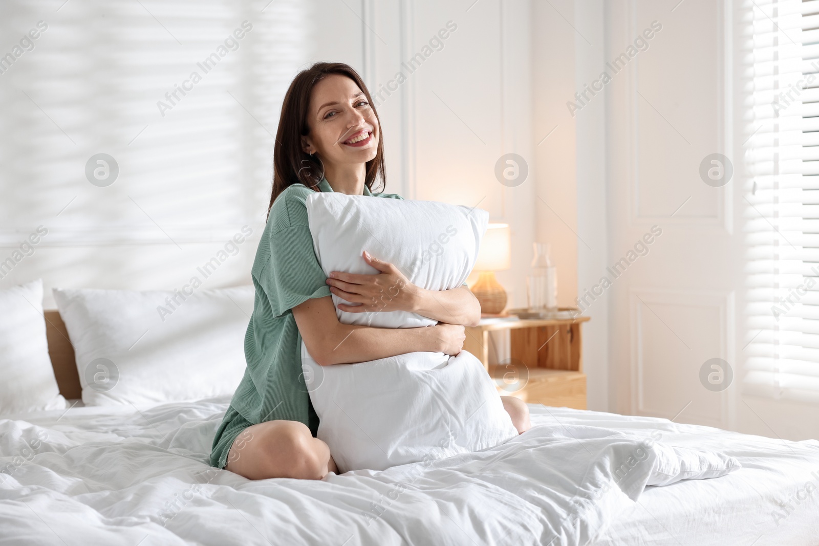 Woman on bed with soft mattress at home Photo of Woman on bed with soft mattress at home