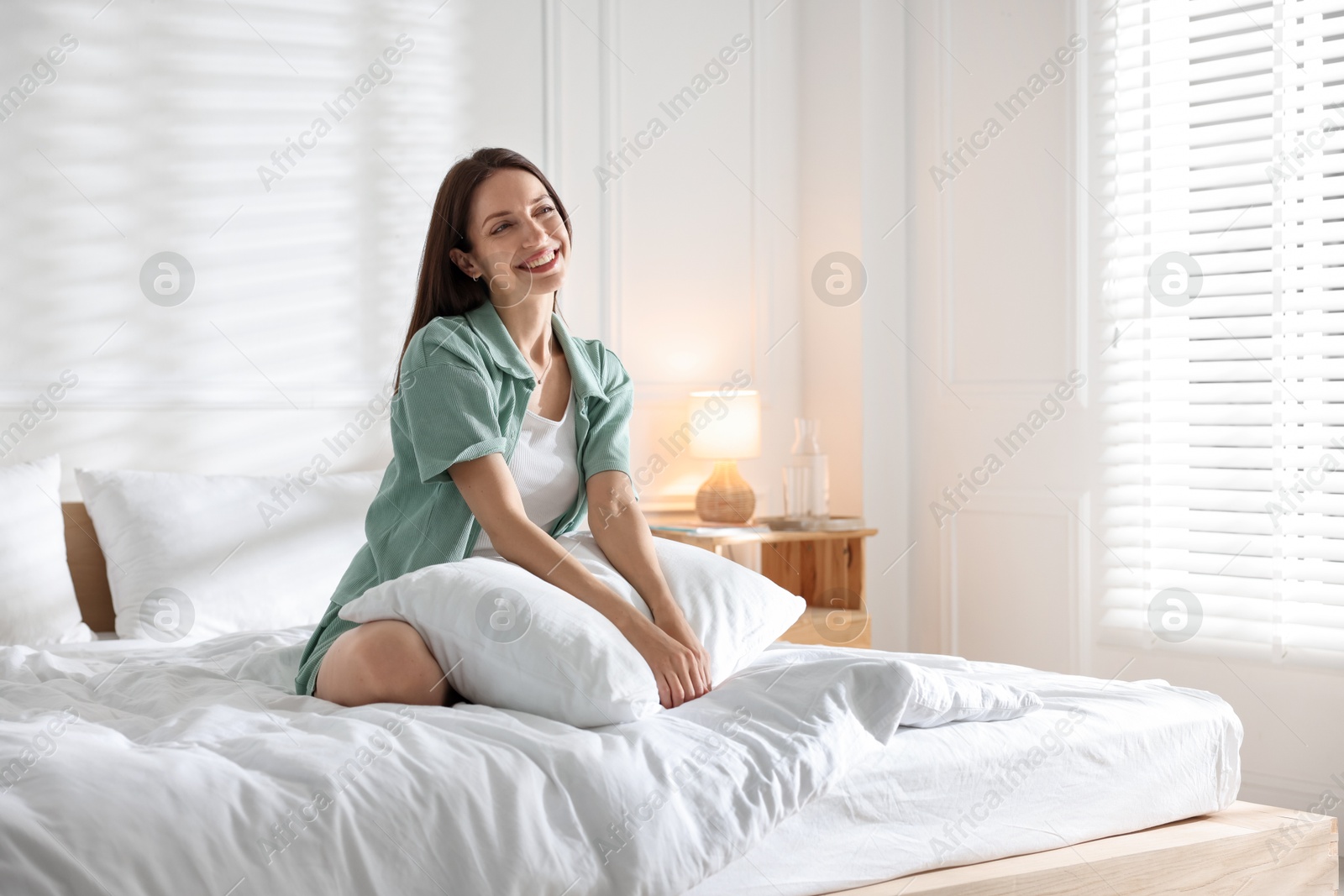Photo of Woman on bed with soft mattress at home. Space for text