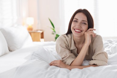 Photo of Woman lying on bed with soft mattress at home. Space for text