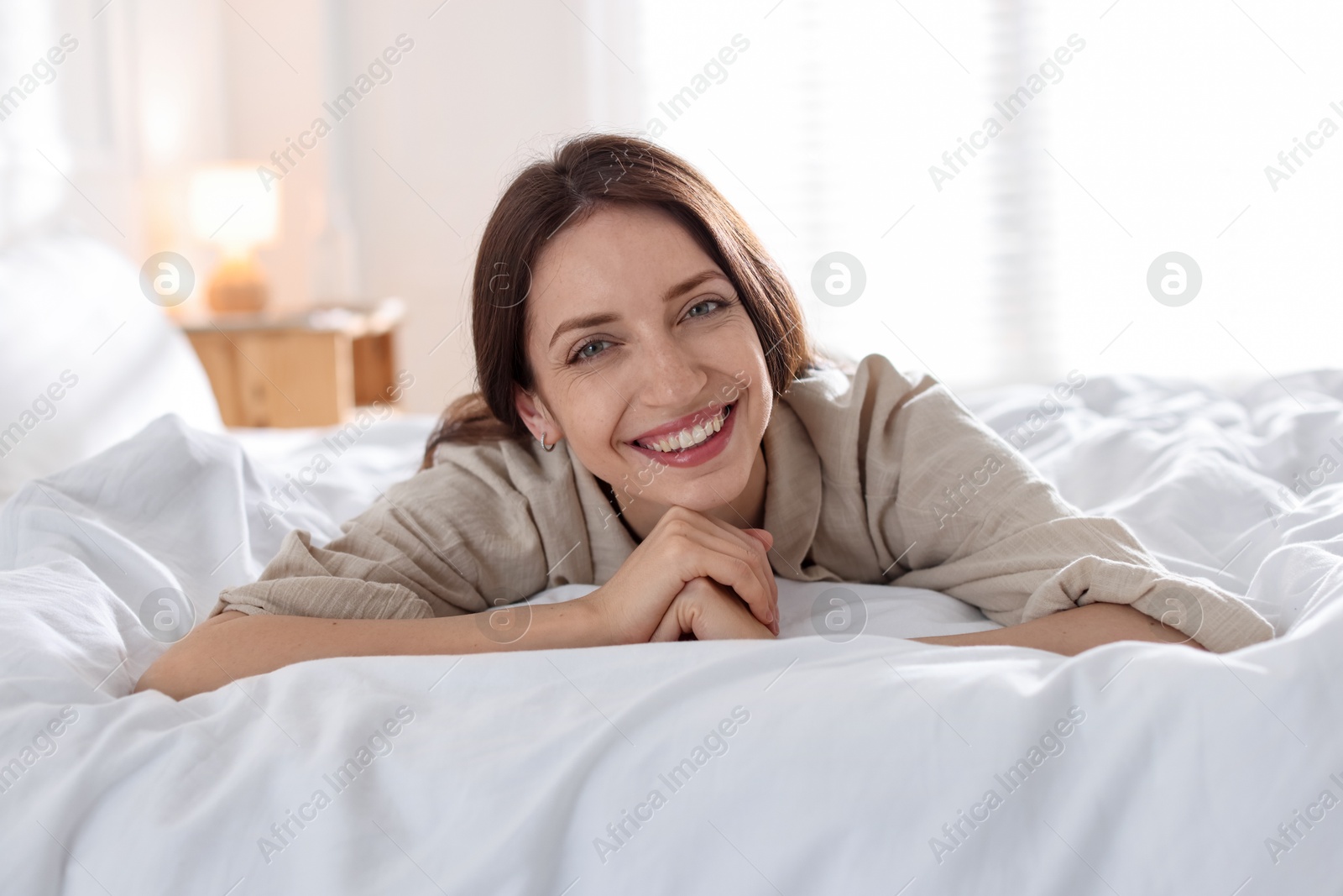 Woman lying on bed with soft mattress at home Photo of Woman lying on bed with soft mattress at home