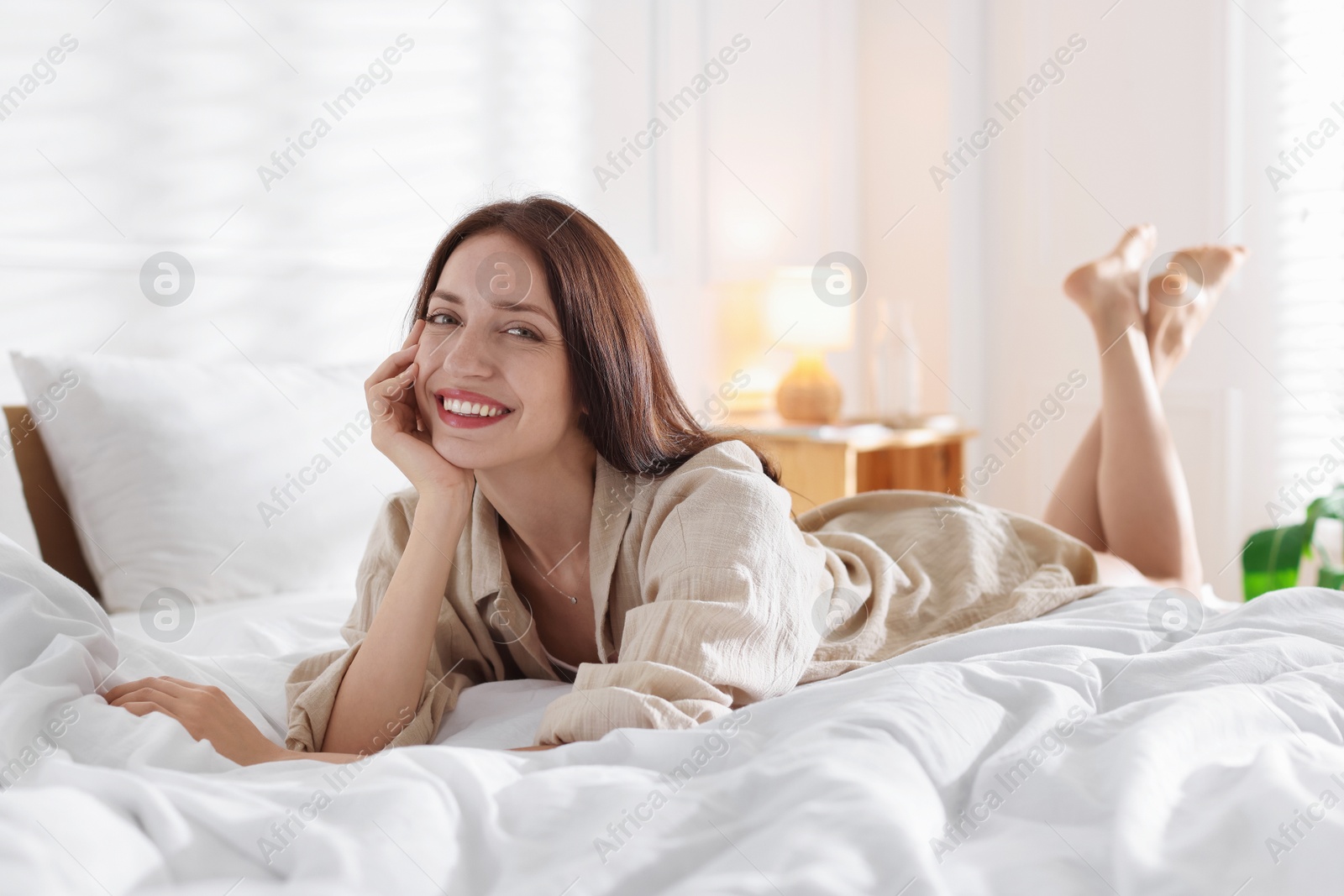 Woman lying on bed with soft mattress at home Photo of Woman lying on bed with soft mattress at home