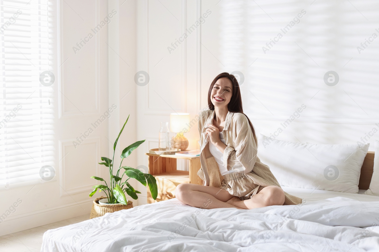 Woman on bed with soft mattress at home. Space for text Photo of Woman on bed with soft mattress at home. Space for text