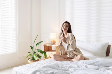 Photo of Woman on bed with soft mattress at home. Space for text