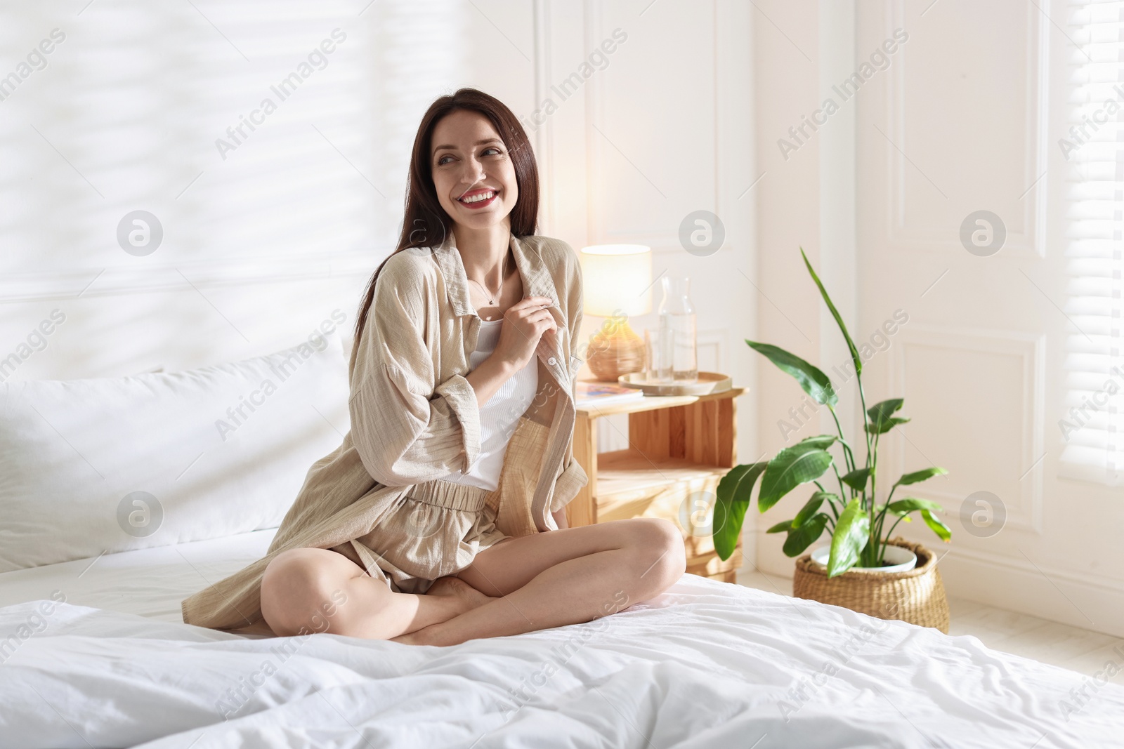 Woman on bed with soft mattress at home. Space for text Photo of Woman on bed with soft mattress at home. Space for text