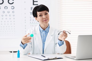 Photo of Portrait of professional ophthalmologist with glasses and contact lenses at white table in clinic