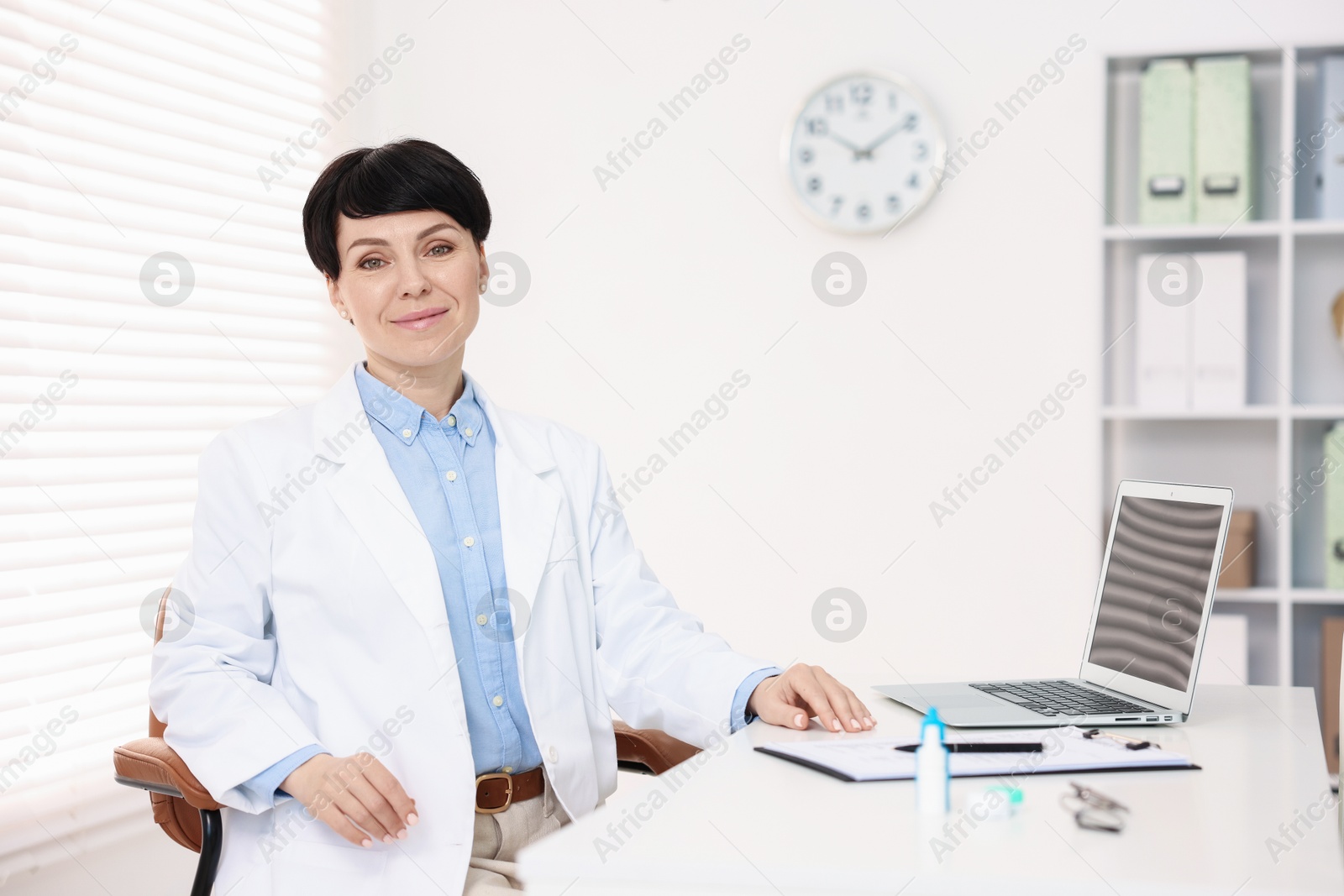 Photo of Portrait of professional ophthalmologist at white table in clinic