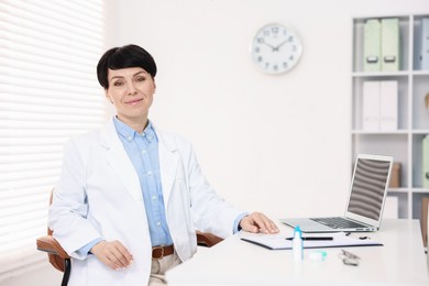 Photo of Portrait of professional ophthalmologist at white table in clinic