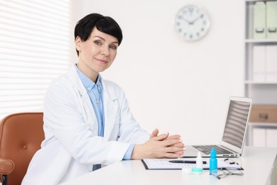 Photo of Portrait of professional ophthalmologist at white table in clinic
