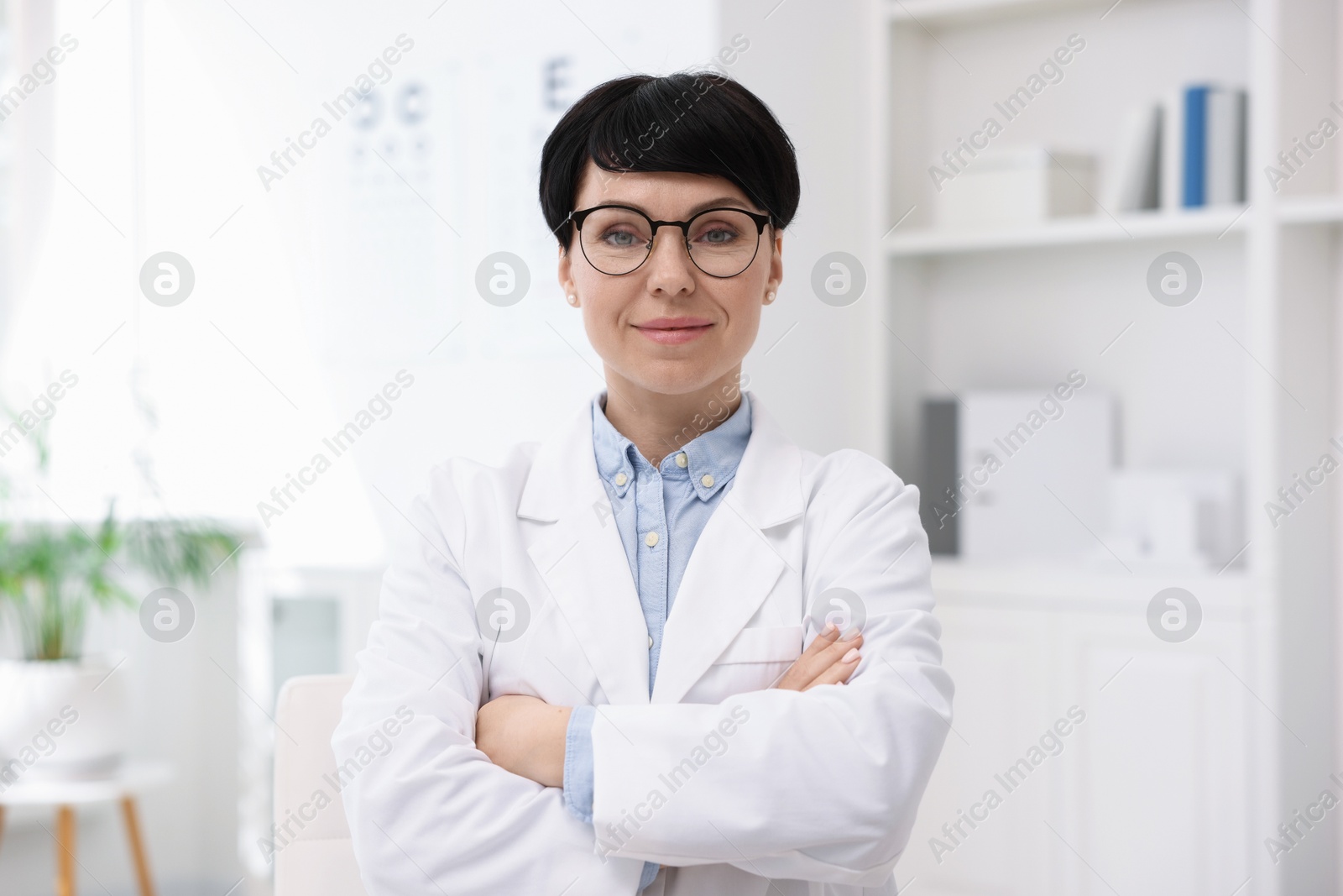 Photo of Portrait of professional ophthalmologist with crossed arms in clinic