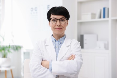 Photo of Portrait of professional ophthalmologist with crossed arms in clinic