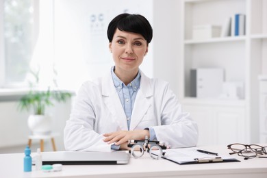 Photo of Portrait of professional ophthalmologist at white table in clinic
