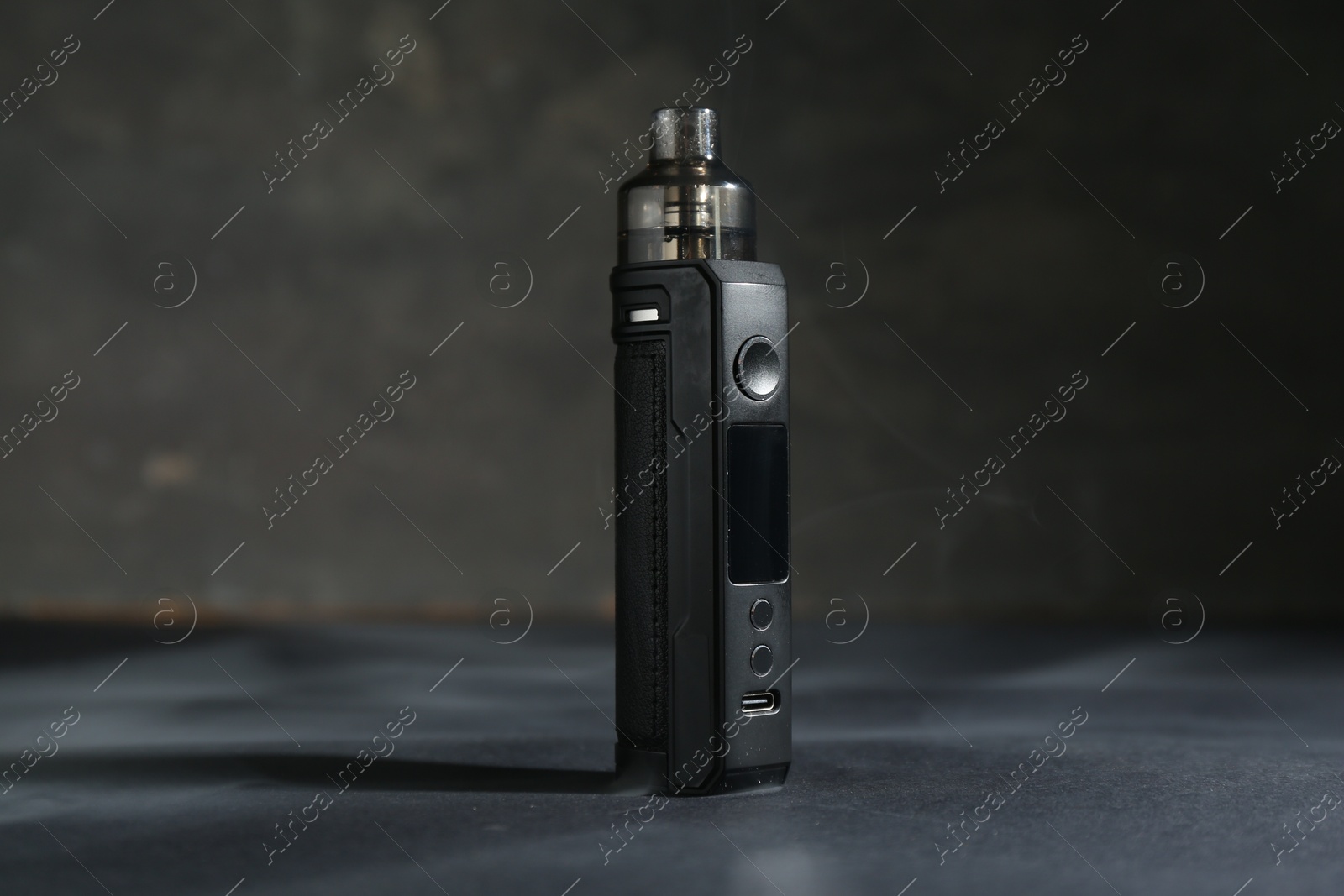 One electronic smoking device on dark table against grey background, closeup Photo of One electronic smoking device on dark table against grey background, closeup