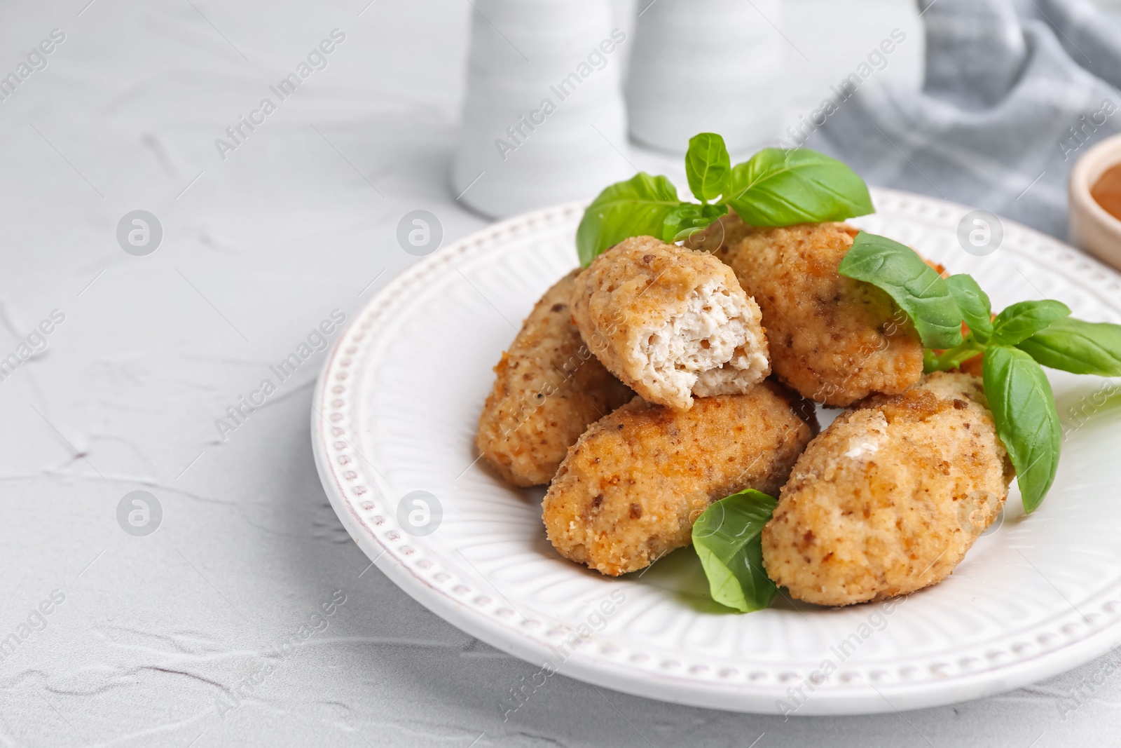 Tasty fried croquettes and basil on white textured table, closeup. Space for text Photo of Tasty fried croquettes and basil on white textured table, closeup. Space for text