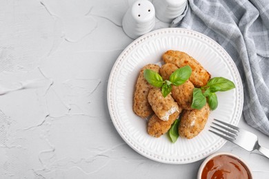Photo of Tasty fried croquettes, basil and sauce on white textured table, flat lay. Space for text