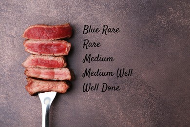 Image of Pieces of delicious beef meat in different degrees of doneness on brown table, top view