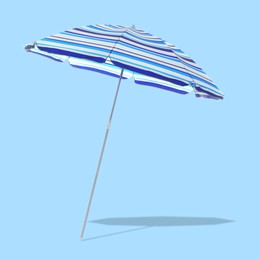 Image of Blue striped beach umbrella casting shadow on light blue background