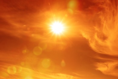 Image of Orange sky with sun and clouds during hot summer weather. Extremely high temperature
