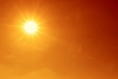 Image of Bright sun in orange sky during hot summer weather. Extremely high temperature