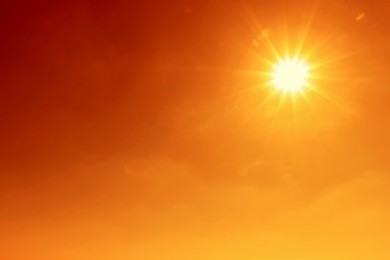 Image of Bright sun in orange sky during hot summer weather. Extremely high temperature
