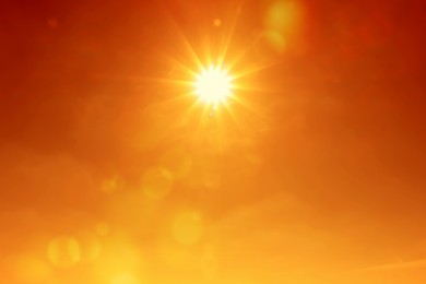Image of Bright sun in orange sky during hot summer weather. Extremely high temperature