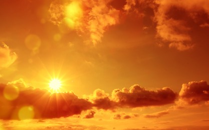Image of Orange sky with sun and clouds during hot summer weather. Extremely high temperature