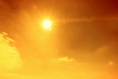 Image of Orange sky with sun and clouds during hot summer weather. Extremely high temperature