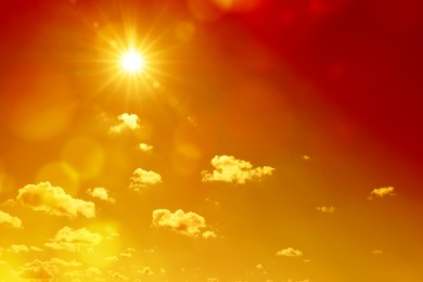 Image of Orange sky with sun and clouds during hot summer weather. Extremely high temperature
