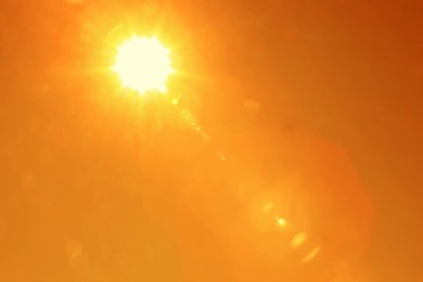 Image of Bright sun in orange sky during hot summer weather. Extremely high temperature