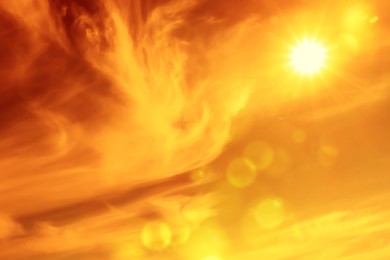 Image of Orange sky with sun and clouds during hot summer weather. Extremely high temperature