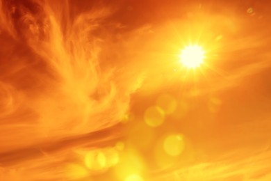 Image of Orange sky with sun and clouds during hot summer weather. Extremely high temperature