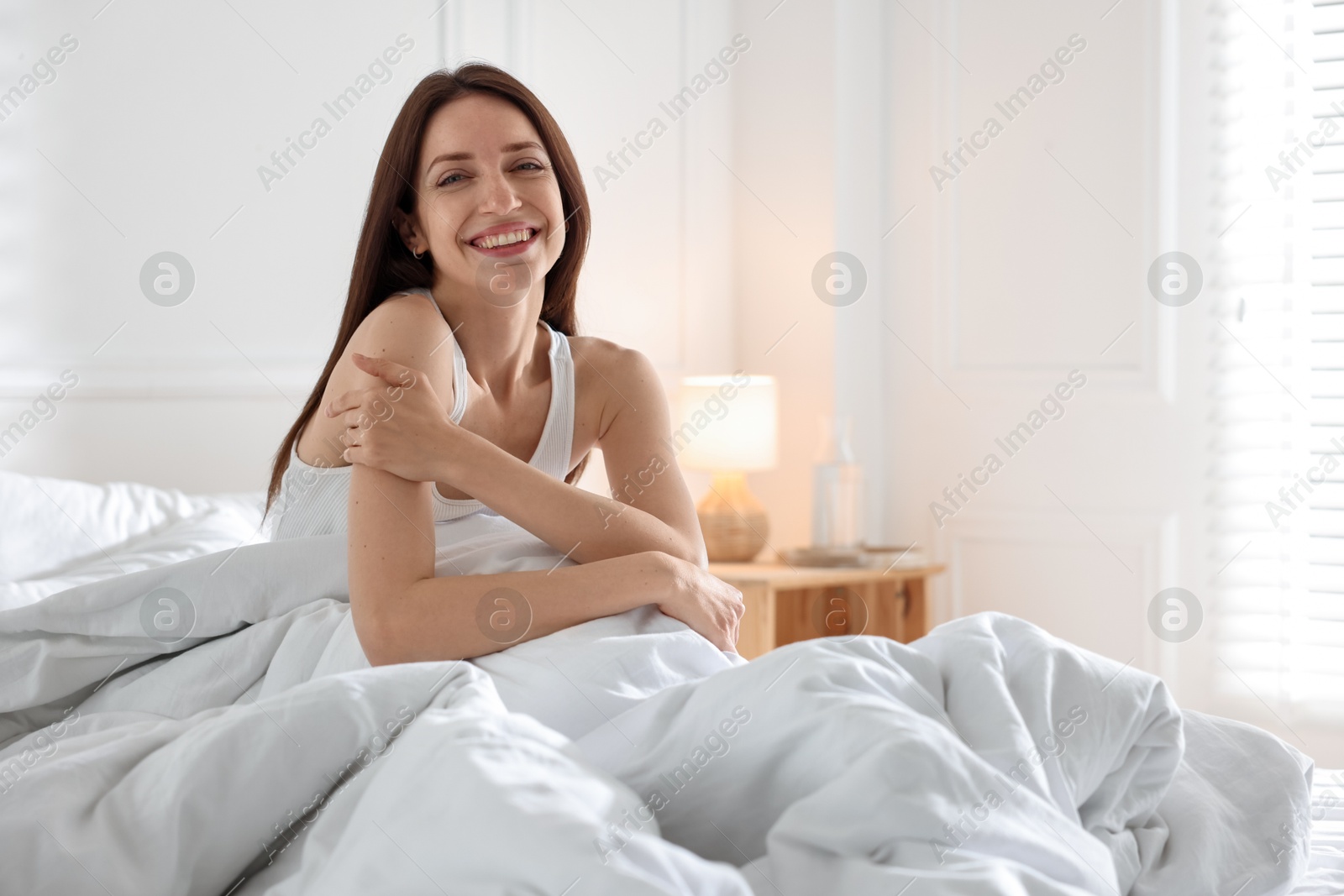 Woman on bed with soft mattress at home Photo of Woman on bed with soft mattress at home