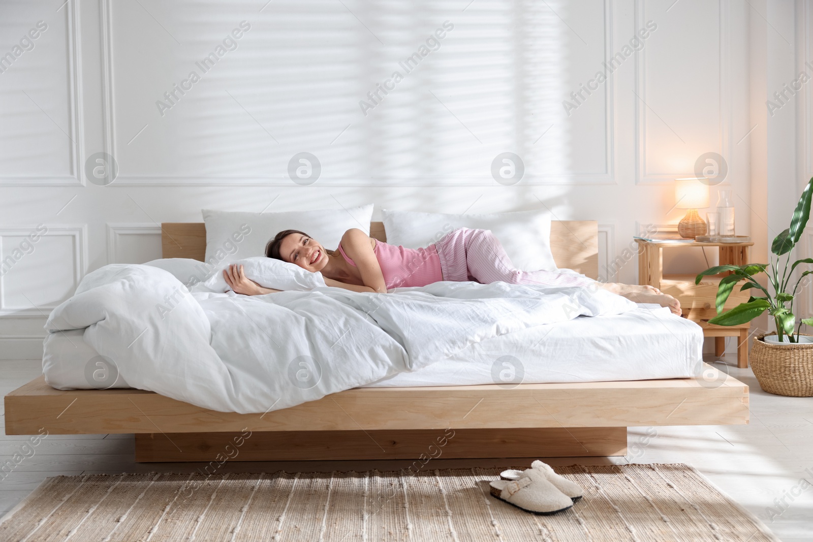 Woman lying on bed with soft mattress at home Photo of Woman lying on bed with soft mattress at home