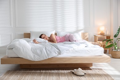 Photo of Woman lying on bed with soft mattress at home
