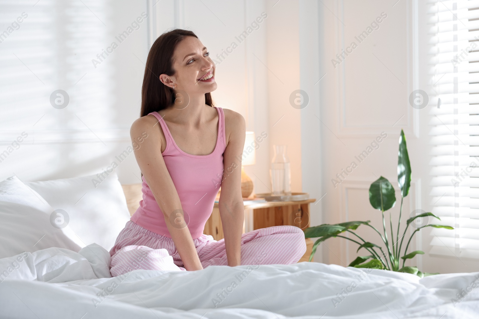 Woman on bed with soft mattress at home. Space for text Photo of Woman on bed with soft mattress at home. Space for text