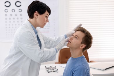 Photo of Professional ophthalmologist examining patient's vision in clinic