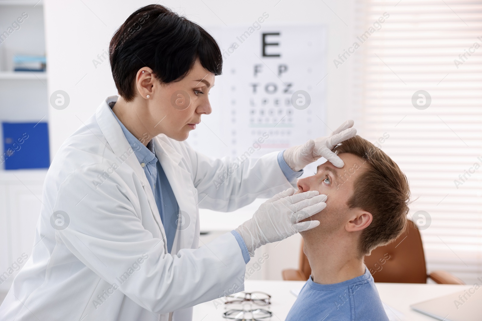 Professional ophthalmologist examining patient's vision in clinic Photo of Professional ophthalmologist examining patient's vision in clinic