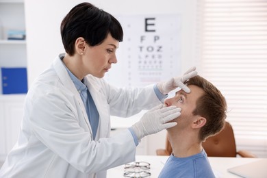Photo of Professional ophthalmologist examining patient's vision in clinic