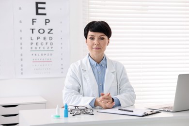 Photo of Portrait of professional ophthalmologist at white table in clinic