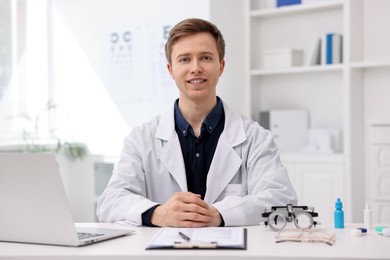 Photo of Portrait of professional ophthalmologist at white table in clinic