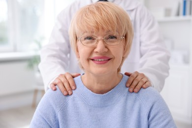 Photo of Professional ophthalmologist and patient with glasses in clinic, closeup