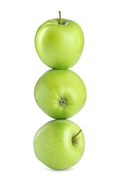 Image of Green apples stacked on top of each other against white background. Balance
